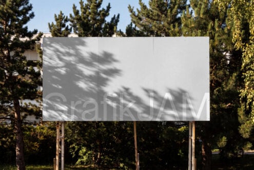Blank billboard mockup surrounded by pine trees with dappled shadow overlay