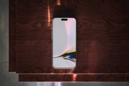 iPhone 14 Pro mockup on dark wood surface showing gradient prism wallpaper display