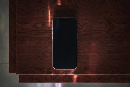 Smartphone mockup on rich wood surface with warm copper lighting