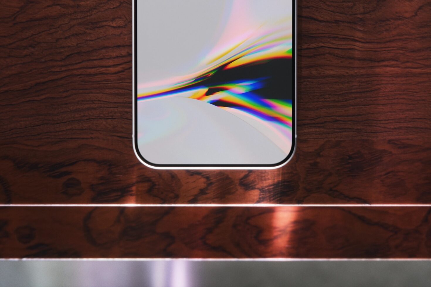 iPhone mockup on wood desk showing rainbow light refraction on screen