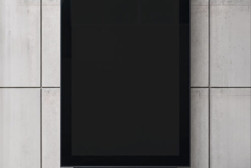 Tablet mockup on concrete wall with black frame centered between textured panels
