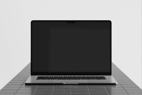 Sleek laptop mockup with black screen on gray surface, minimal lighting setup