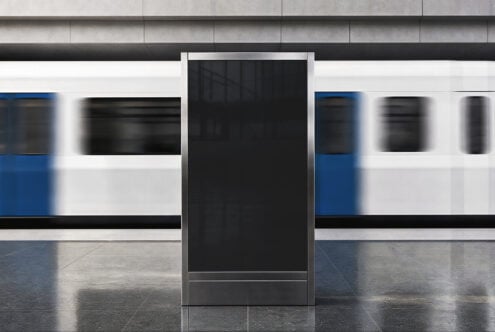 Blank digital display kiosk in modern retail storefront with polished concrete floors