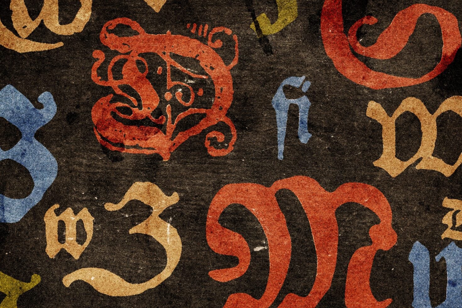 Ornate zodiac symbols in red, gold, blue scattered on dark textured background with grungy finish