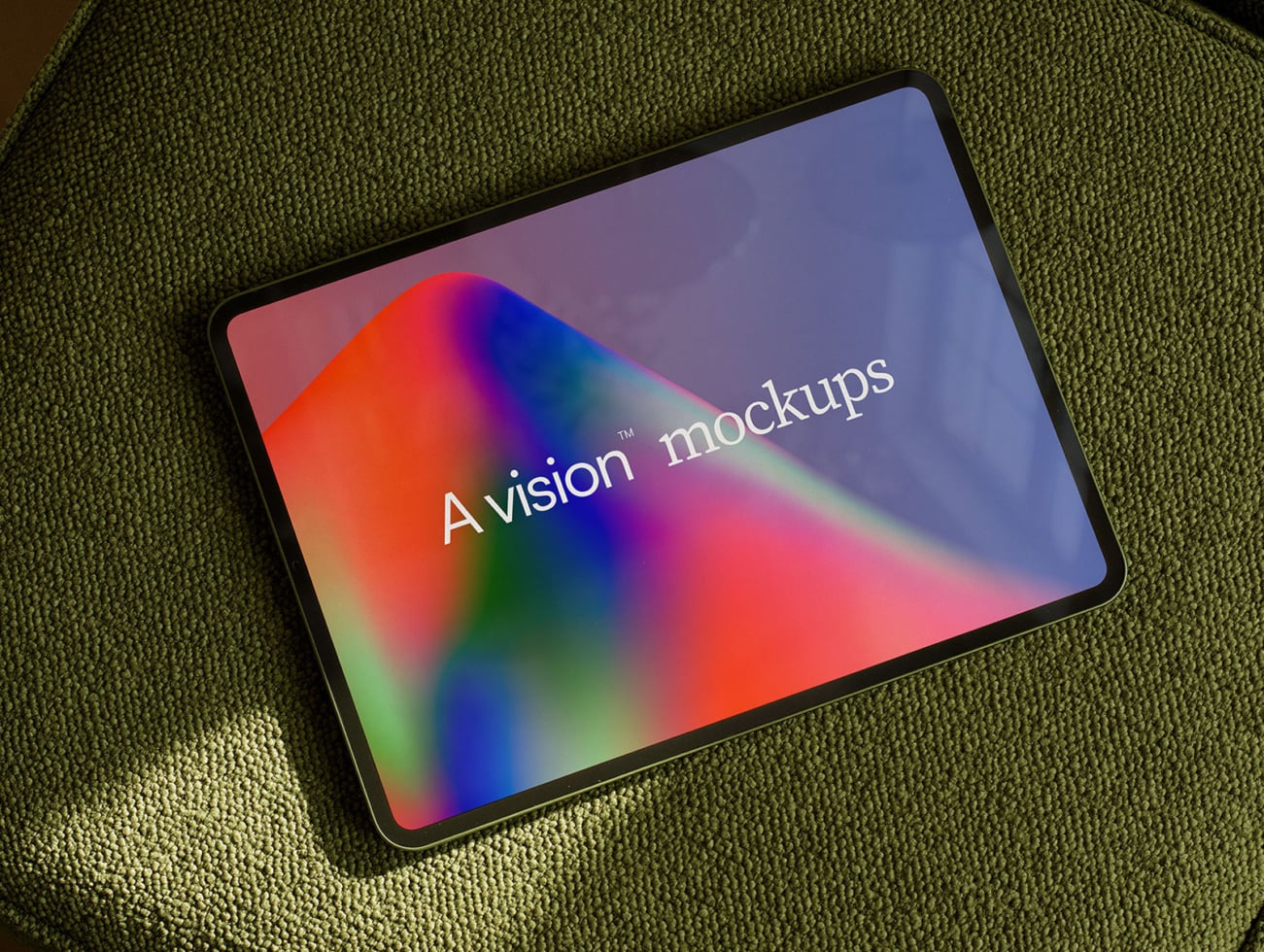 Tablet on olive fabric showing vibrant gradient display with sample text overlay