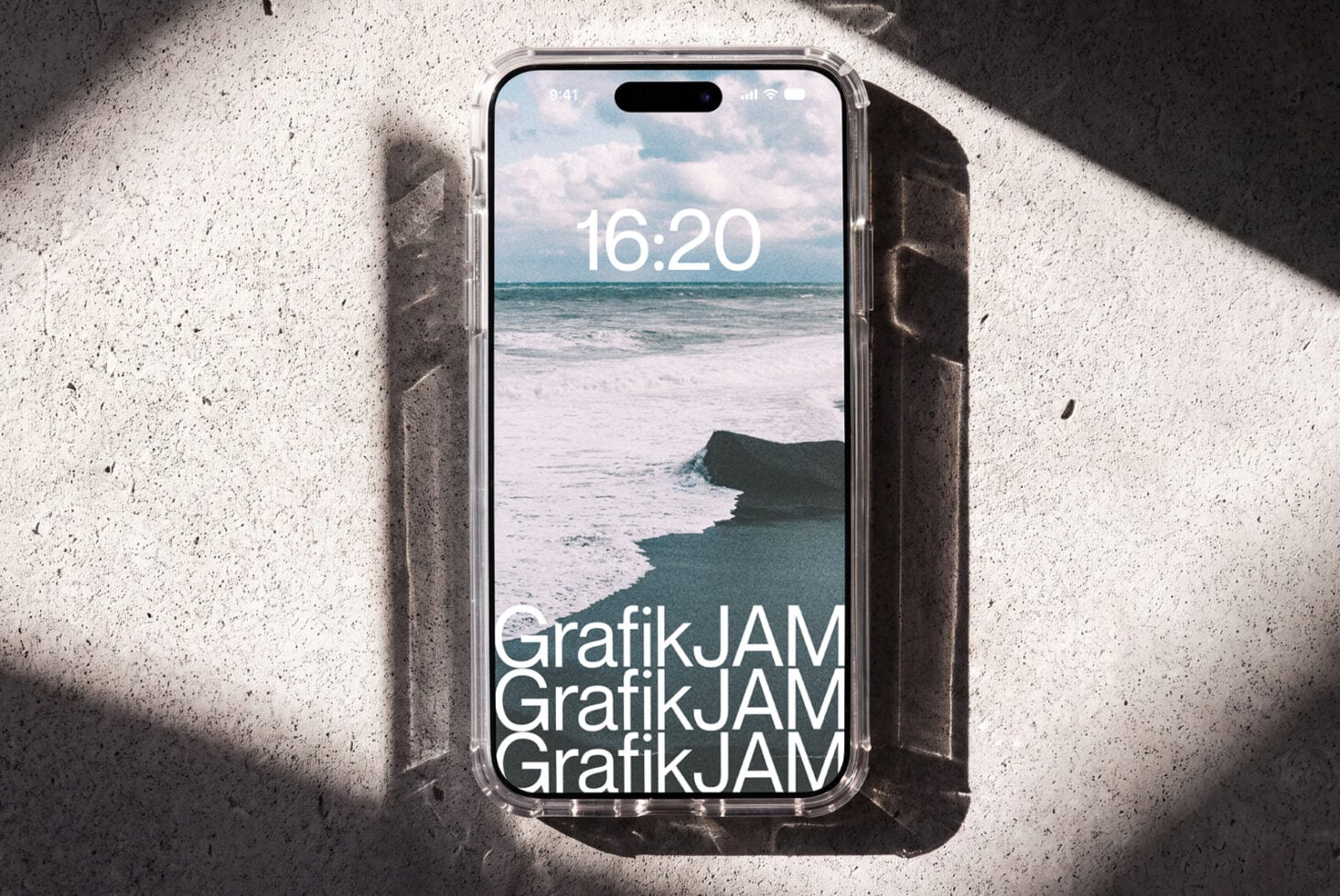 iPhone 14 Pro mockup showing beach lockscreen with GrafikJAM branding on concrete