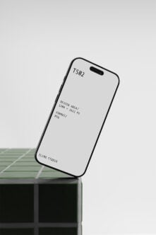 iPhone 14 Pro mockup tilted on concrete block with green tile background