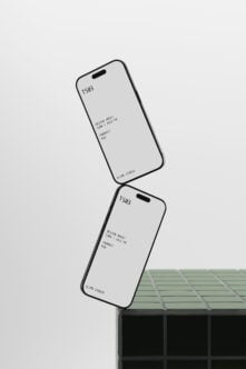 Two tilted iPhones with blank screens resting on geometric blocks, clean mockup setup