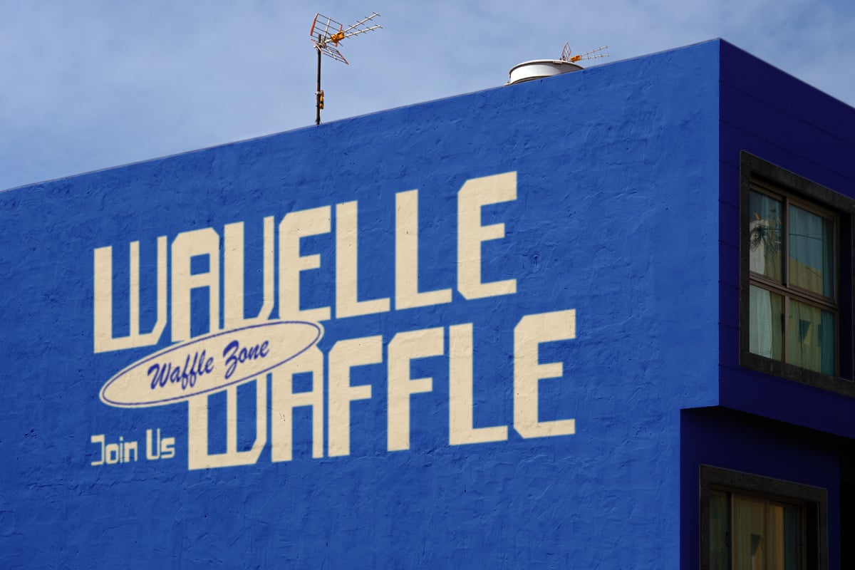 Vintage diner mural on bright blue building wall with cream lettering saying "Waffle Zone Join Us Waffle"