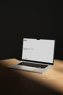 MacBook Pro mockup on wooden desk with blank screen showing specs