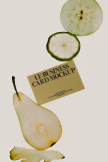 Cream business card mockup balanced between fresh fruit slices on neutral background
