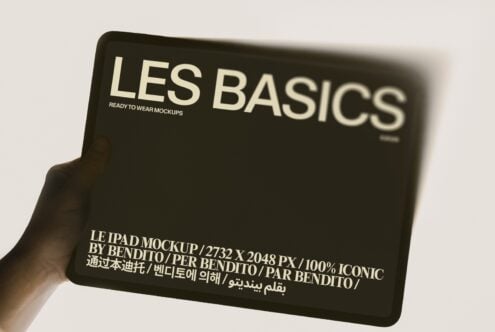 Hand holding black iPad mockup with Les Basics branding in cream text