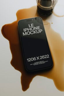 iPhone mockup in hand with coffee cup, moody shadows on white surface