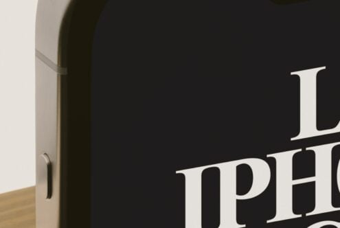 Open door with serif type on dark wall, minimal interior shot