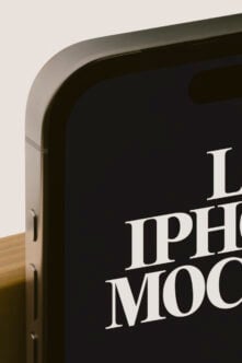 Close-up of rounded monitor frame displaying serif typography on dark screen with wooden base visible
