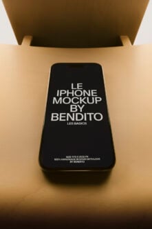 iPhone mockup on beige desk with olive chair overhead, screen displaying text layout