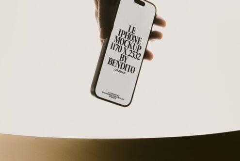 Hand holding white iPhone with black text layout mockup displayed on screen