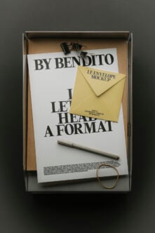 Flat lay of By Bendito letterhead, yellow envelope mockup, pen, clips inside kraft box