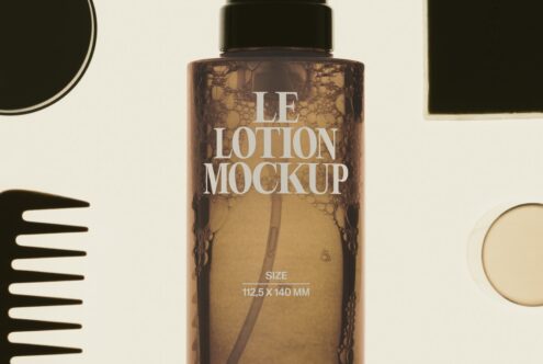 Tall amber lotion bottle with black cap surrounded by minimalist beauty accessories on cream background