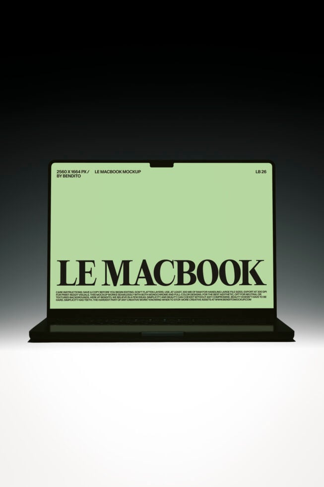 Black MacBook laptop displaying pale green screen with bold serif typography