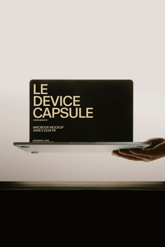 Macbook held in hand displaying black screen with cream typography mockup