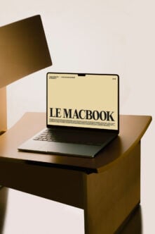 MacBook mockup on wooden desk with cream screen display in warm lighting