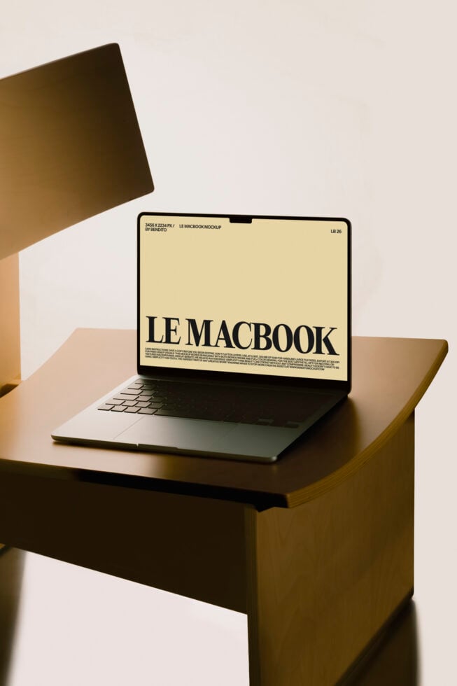 MacBook mockup on wooden desk with cream screen display in warm lighting