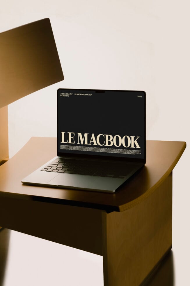 MacBook sitting on olive wood desk with minimalist shadow lighting setup