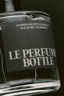 Luxury perfume bottle mockup with textured label, water droplets, dark moody lighting