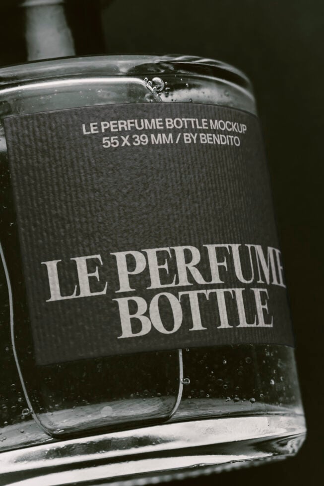 Luxury perfume bottle mockup with textured label, water droplets, dark moody lighting