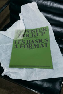 Bright green poster mockup on white tissue paper draped over black leather chair