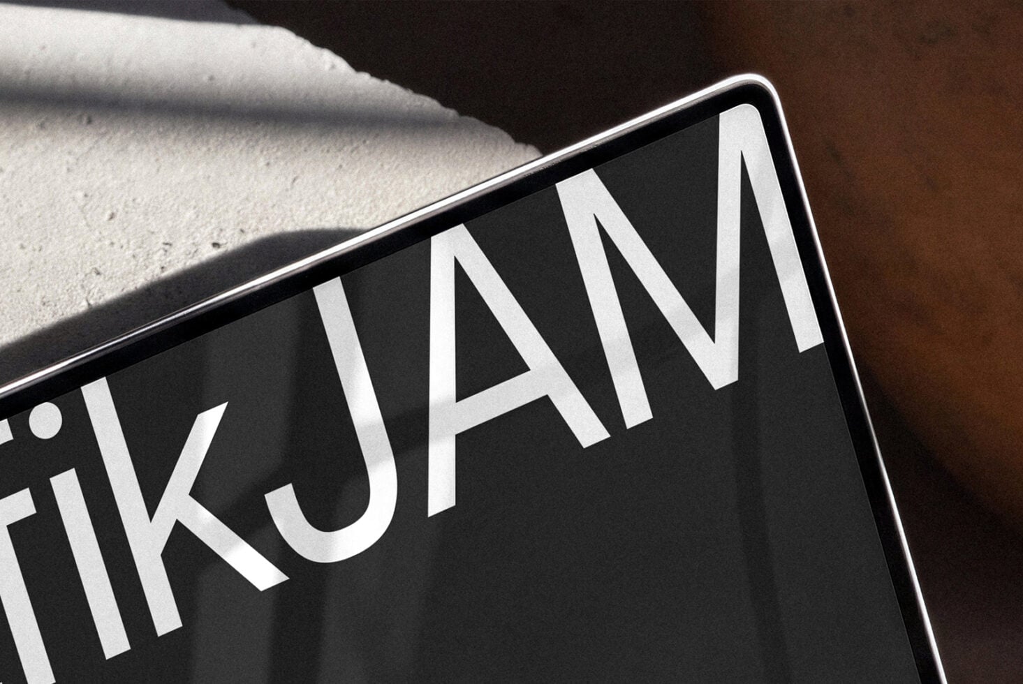 Close-up of black business card with white sans-serif typography casting shadow on concrete surface