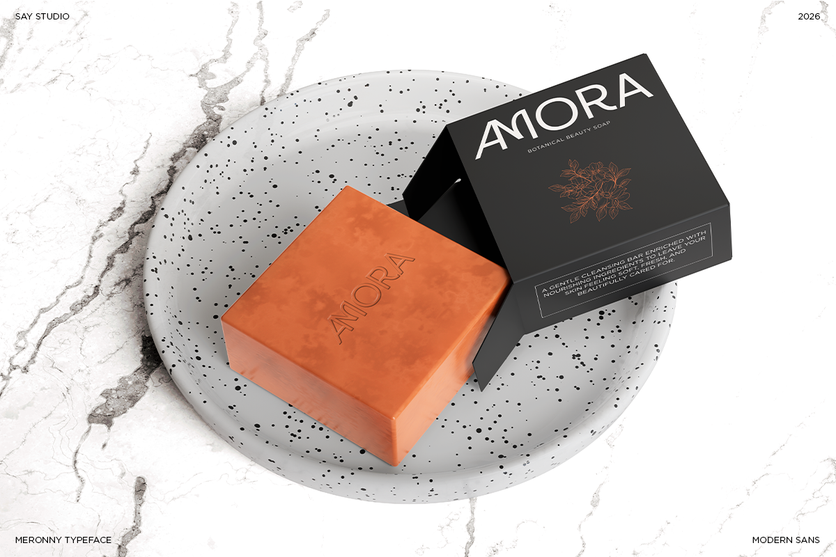 Amora beauty soap bar with black box on speckled concrete dish, marble background