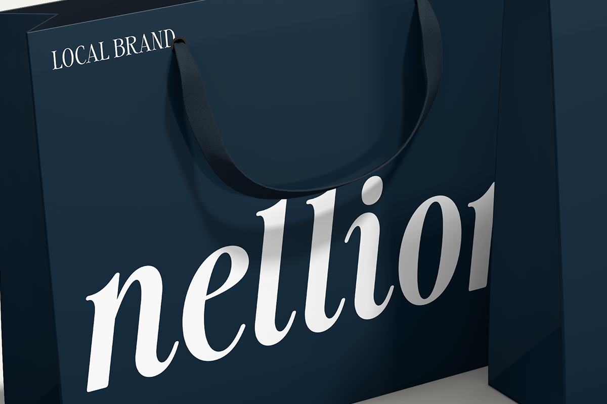 Luxury shopping bag mockup with serif typography showing "nelloi" branding on deep navy