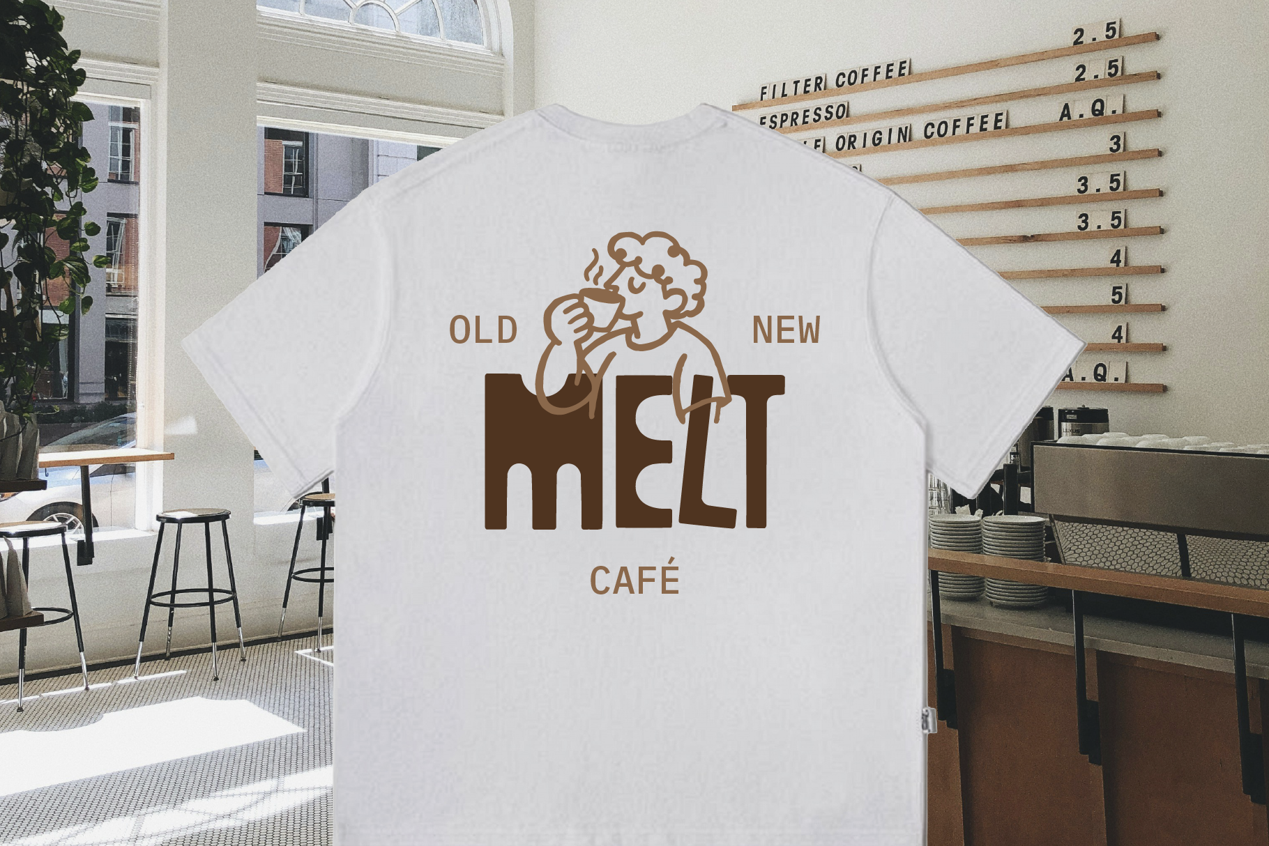 White tee with retro coffee shop logo in tan brown, styled in modern cafe setting