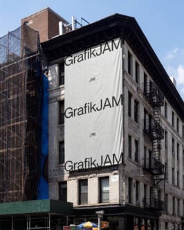 Large billboard mockup wrapping around historic building corner with GrafikJAM branding repeated three times