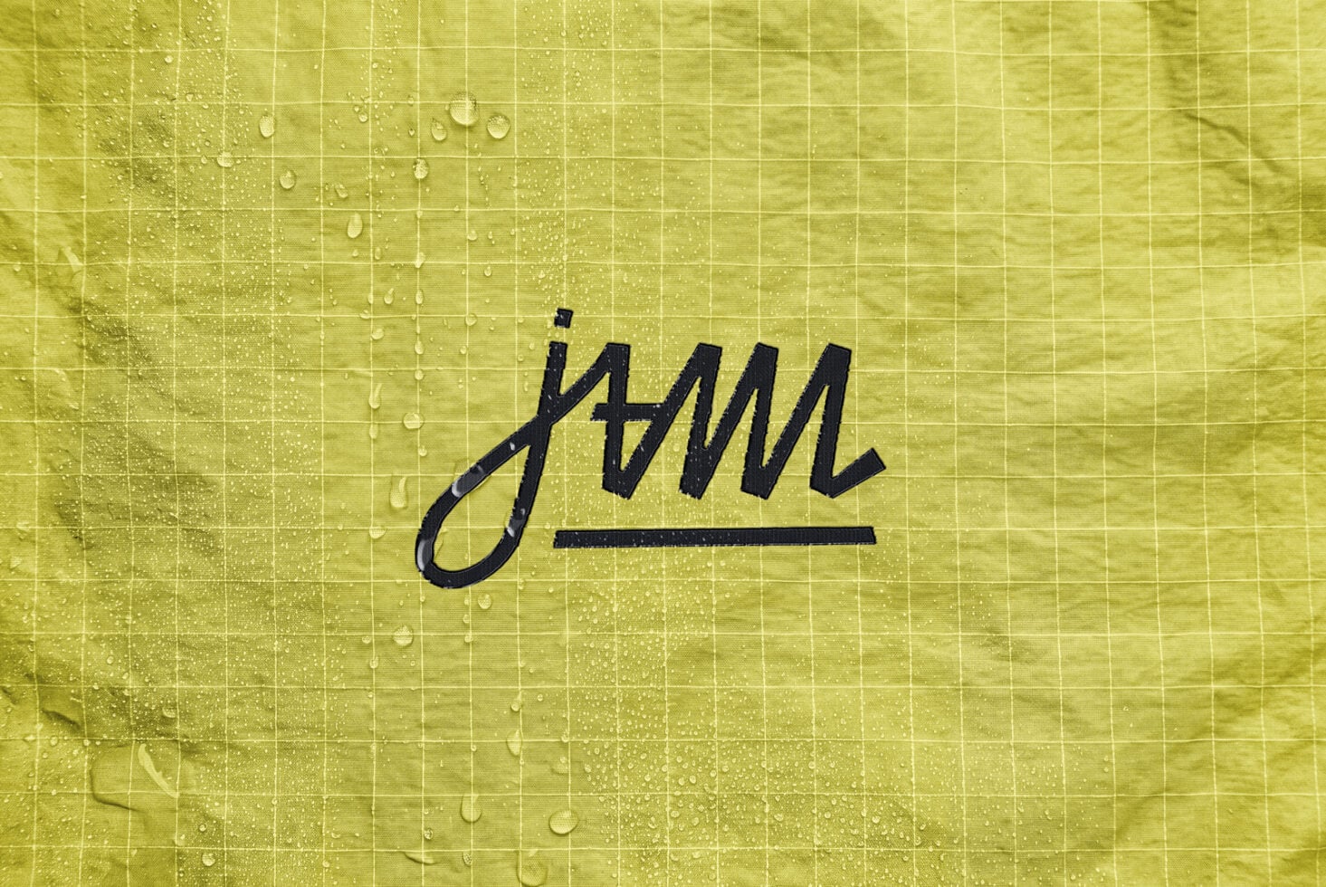 Handwritten signature sketch on wet yellow tile with water droplets
