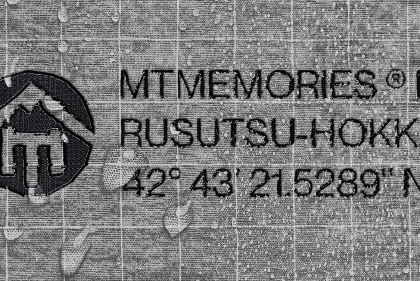 Memories Resubmiyok logo stamped onto textured fabric with water droplets