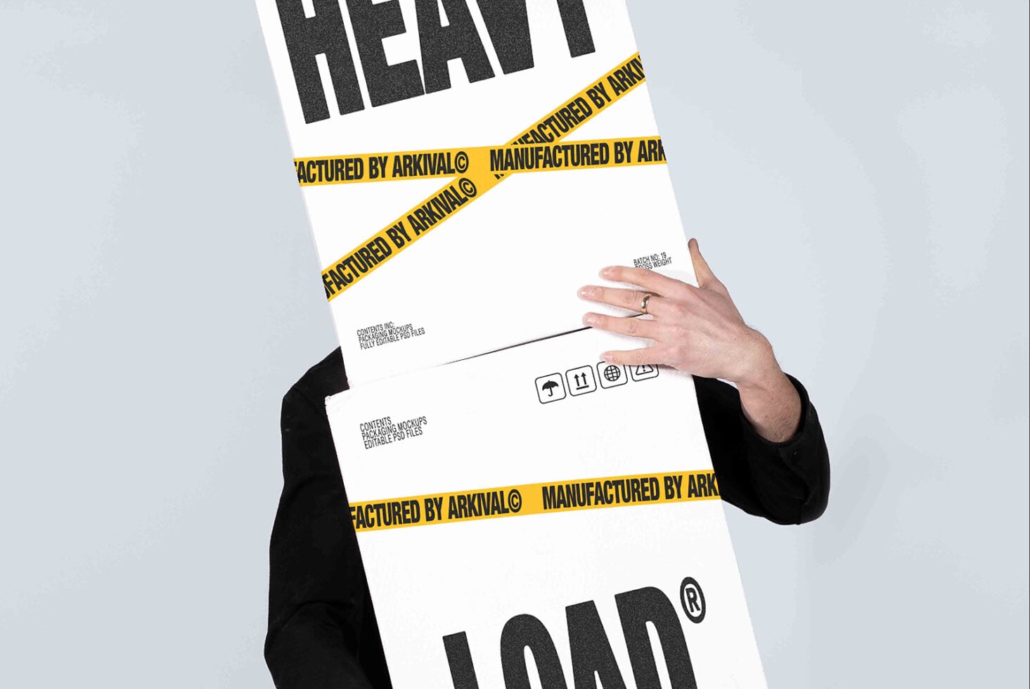Hands holding white box mockup with yellow caution tape, black sleeves visible, shipping label details shown