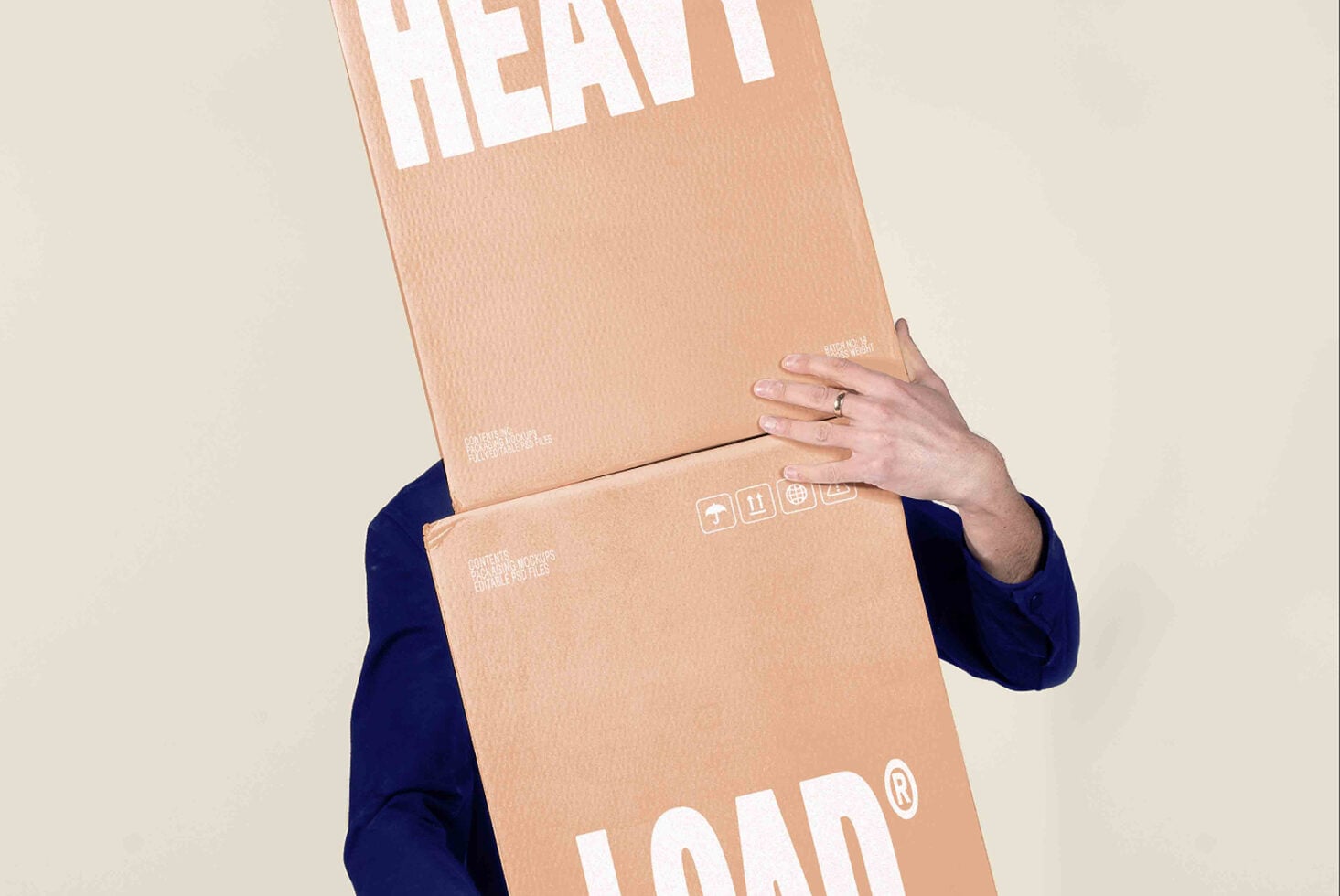 Person in navy sleeve holding stacked cardboard boxes with LOAD branding, shipping labels visible