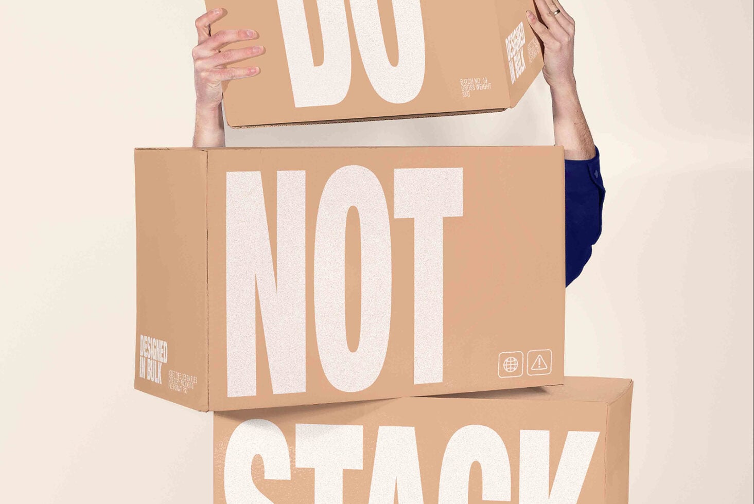 Hands holding stacked cardboard boxes with bold white typography mockup