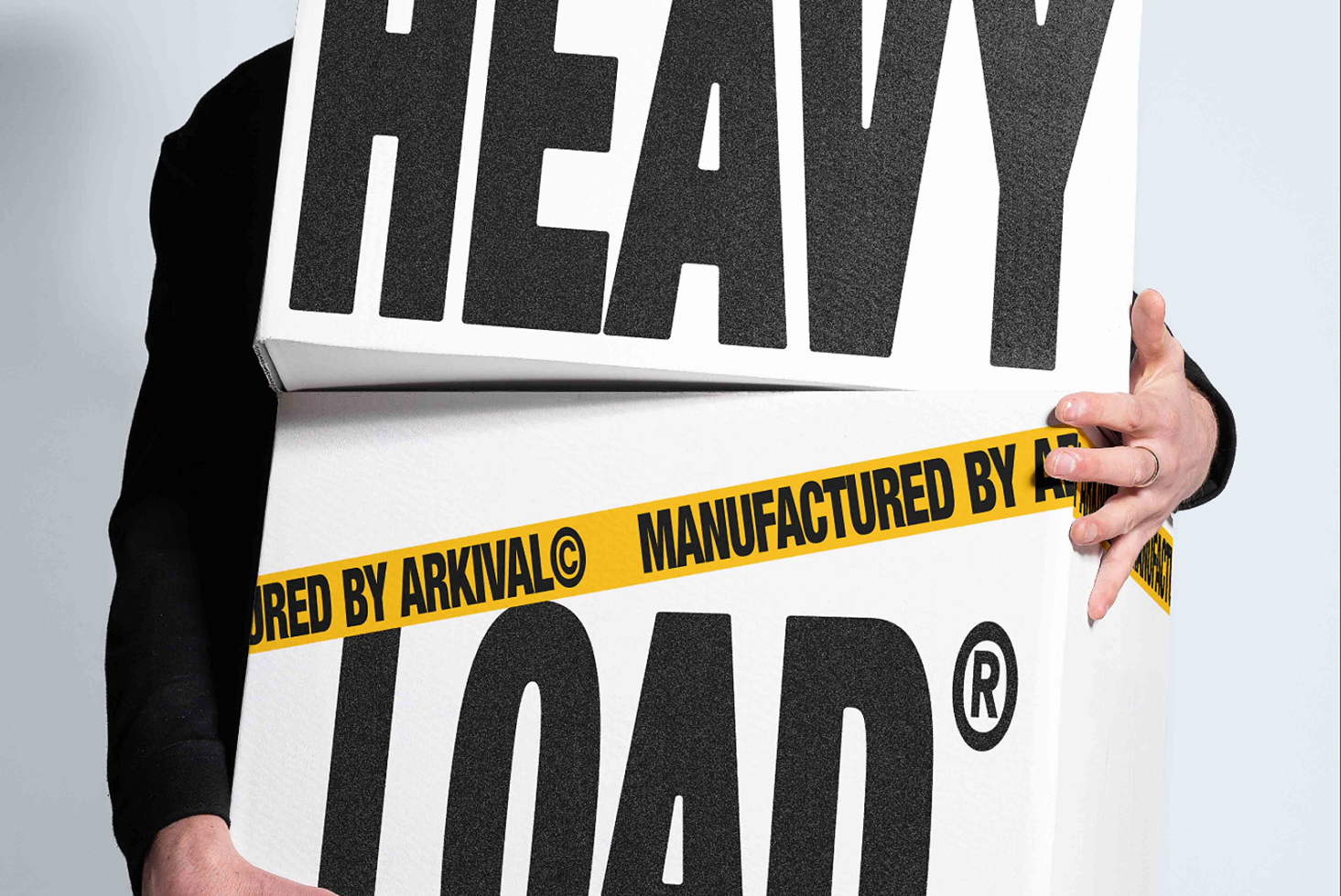 Heavy textured typeface with yellow warning tape across bold black letters on white background