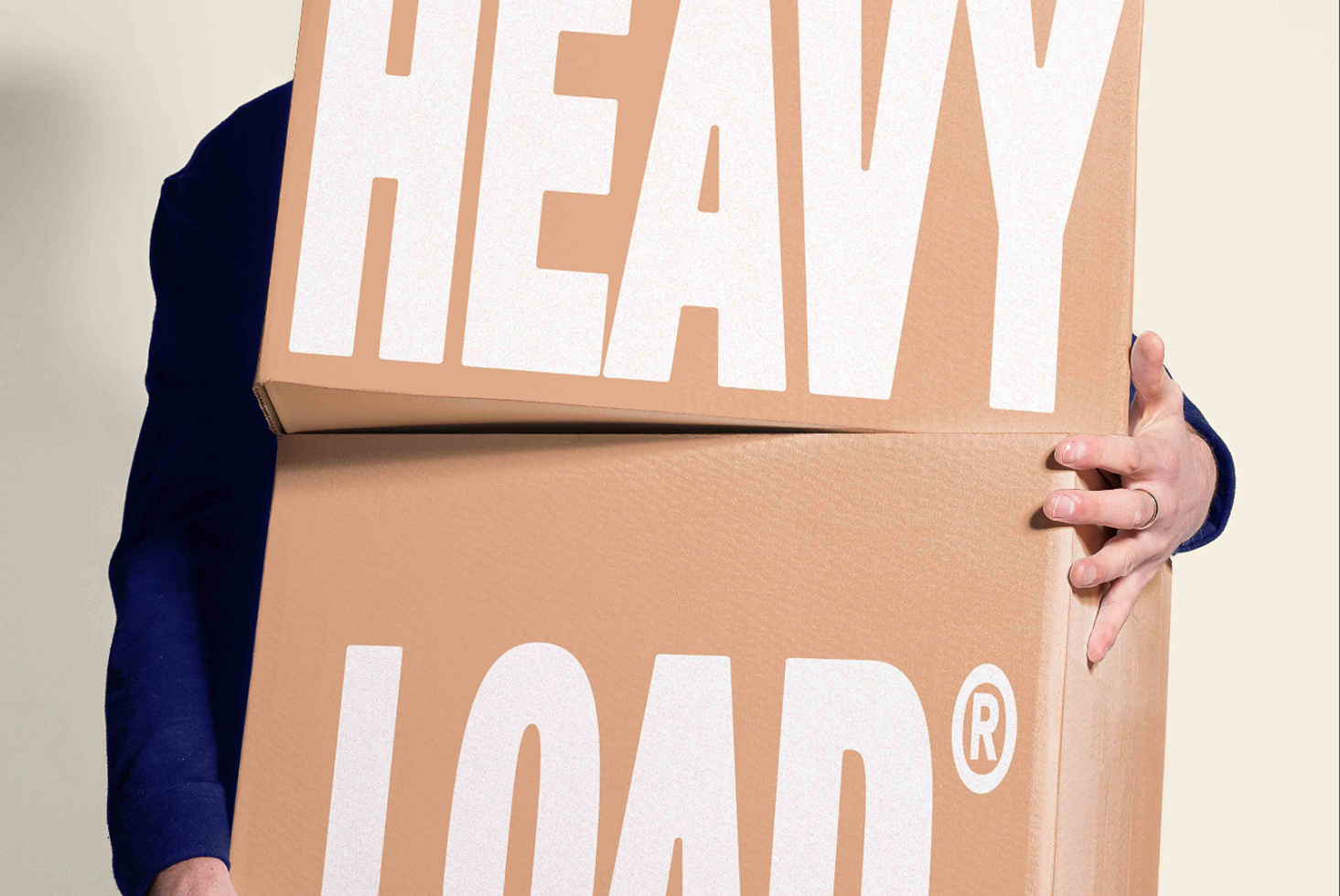 Person in navy sleeve holding cardboard box mockup with white cutout lettering