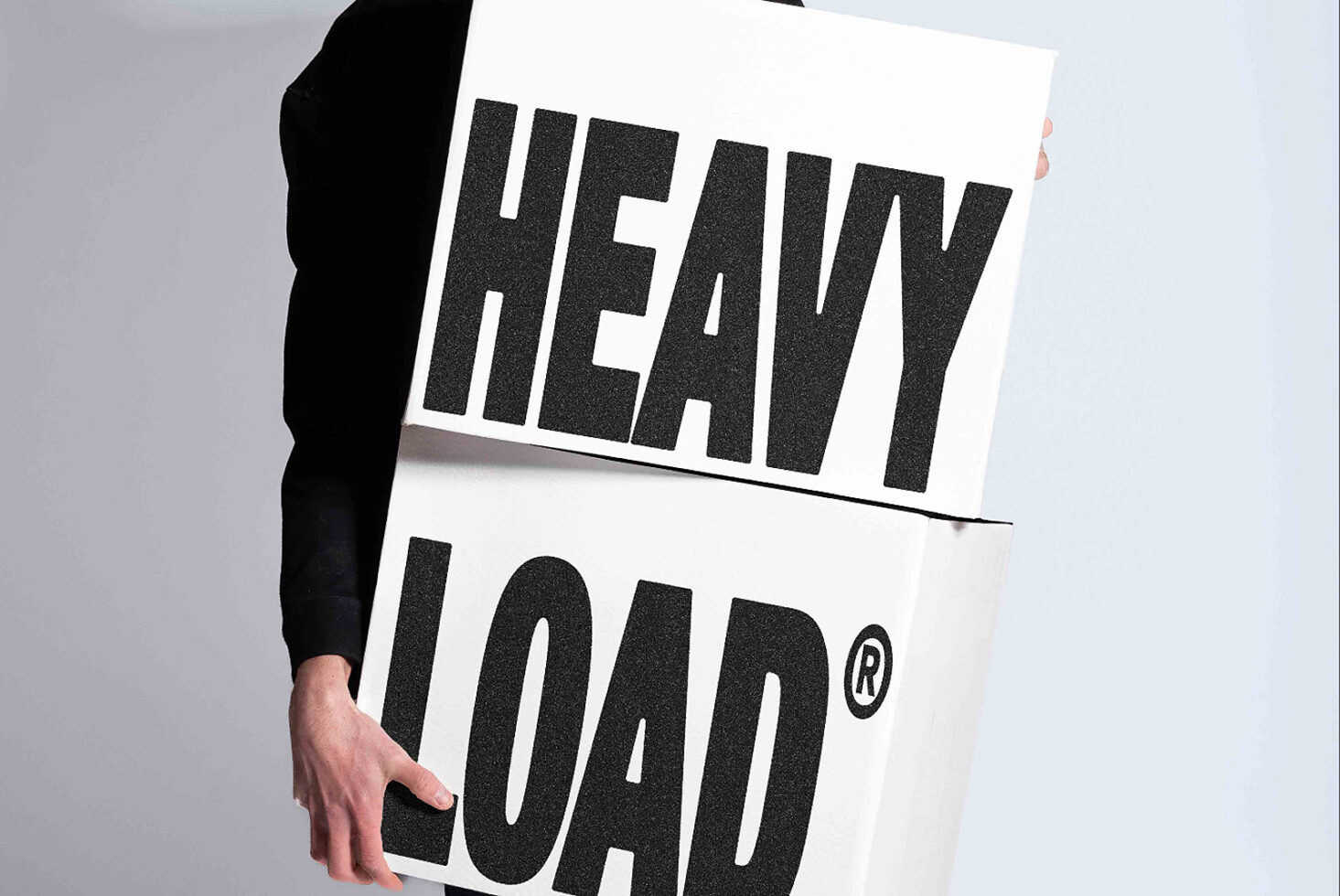 Person holding white poster with heavy load text in chunky black letters