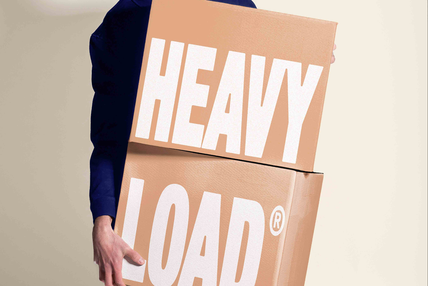 Person holding stacked cardboard boxes with heavy load text in bold white lettering