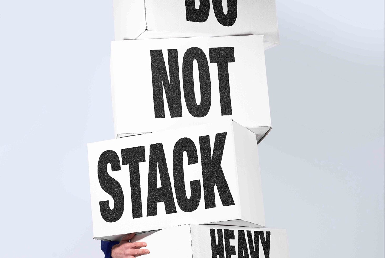 Stacked white cards with bold black typography spelling out motivational words in hand