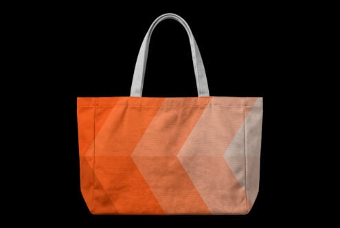 Oversized tote bag with bold orange to neutral gradient chevron pattern on black background