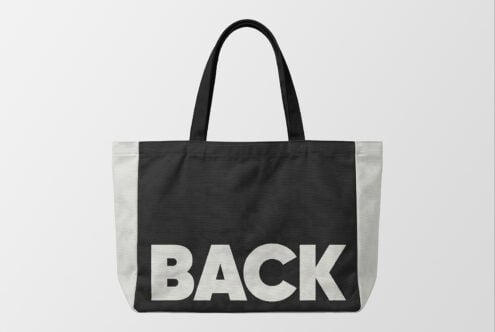 Black tote bag mockup with cream colorblock sides, bold BACK text front facing
