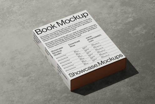 Book mockup sitting on concrete with brown spine showing portfolio text layout