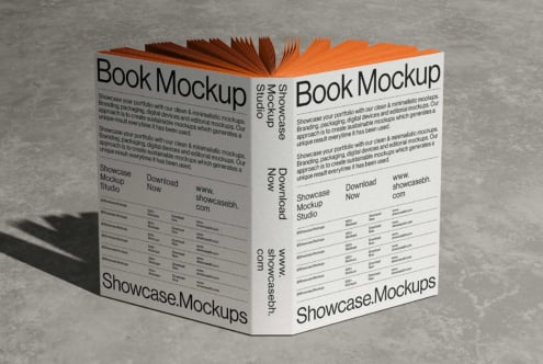 Open book mockup with orange pages on concrete, front cover shows branding layouts